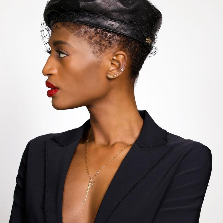 Most Gifted: 14k gold Curved Quill Climber Earrings styled on a ear of a women dressed in black with a black leather hat and fish net veil