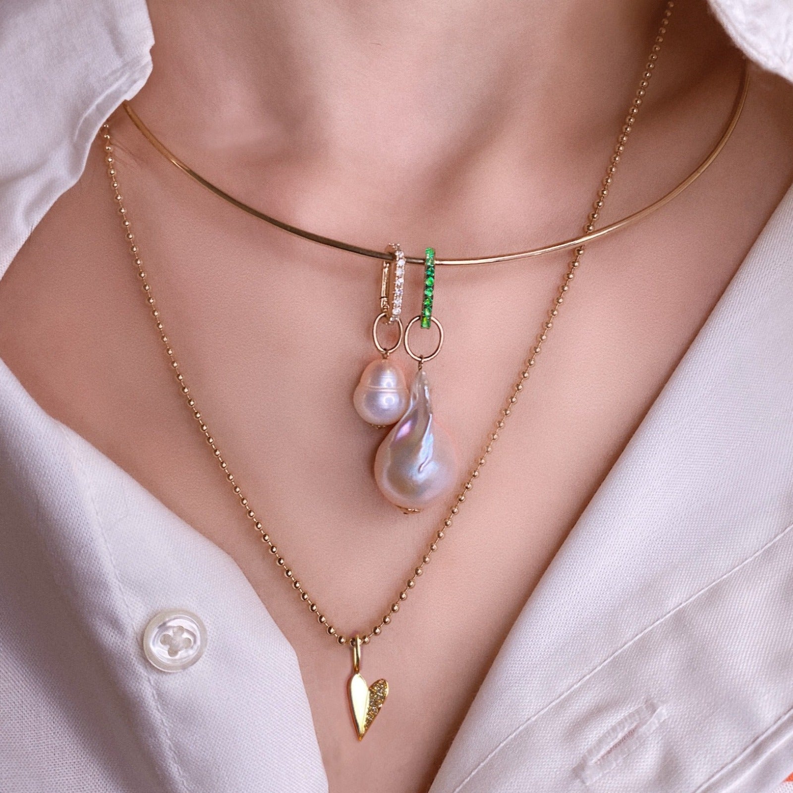 14k yellow gold Small Diamond Charm Lock with emerald pavé styled on a neck locked on a wire choker necklace and mini baroque pearl charm.