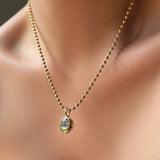 3mm bead chain necklace in yellow gold on the body with a molten solitaire charm with a round diamond.