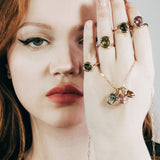 Colorful gemstone rings and charms in organic gold settings.