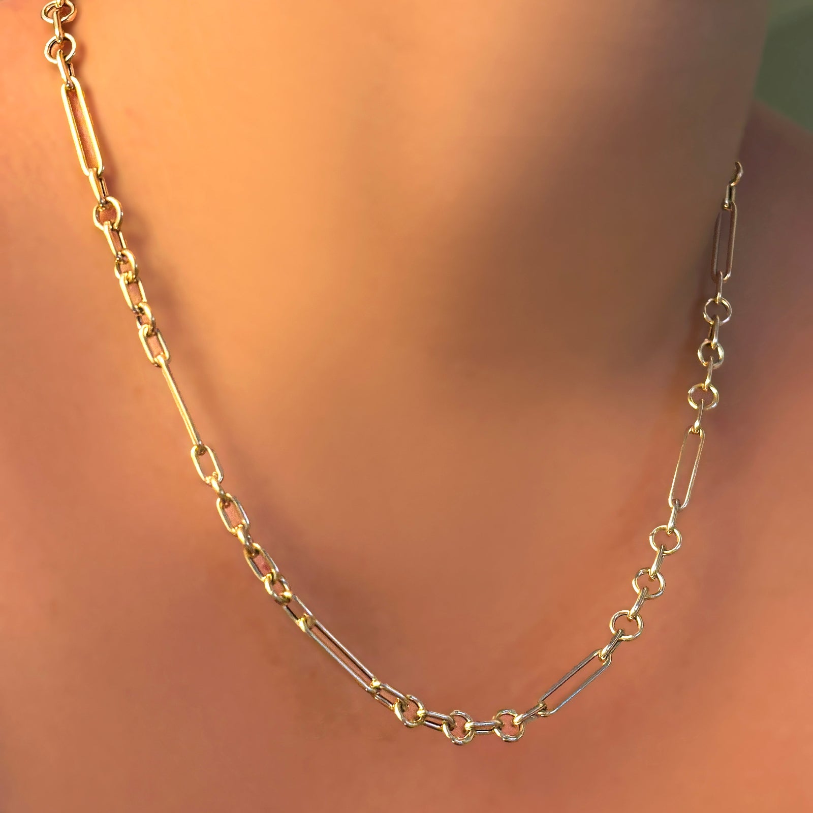 A 14K yellow gold 6 mm irregular cable chain necklace on a model's neck.