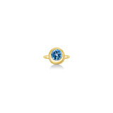 A 14K yellow gold round ring, with a bezel set faceted blue topaz gemstone, sits on a white background with drop shadow.
