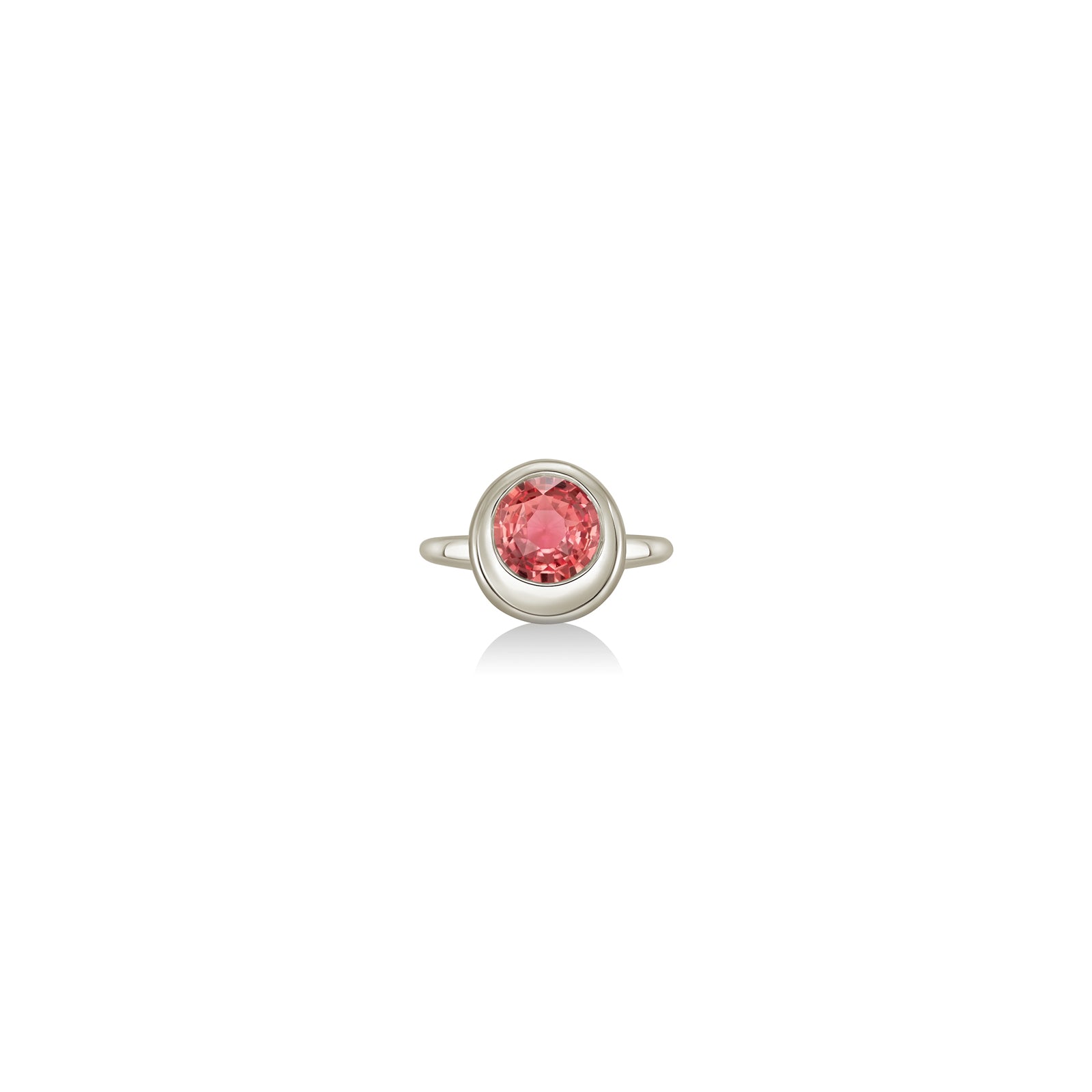 A 14K white gold round ring, with a bezel set faceted sapphire gemstone, sits on a white background with drop shadow.