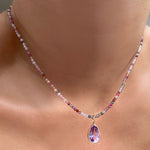Shimmering slim gemstone beaded necklace made of 2mm faceted stones in tourmaline on a gold linking lobster clasp. Styled on a neck layered with pear solitaire charm.