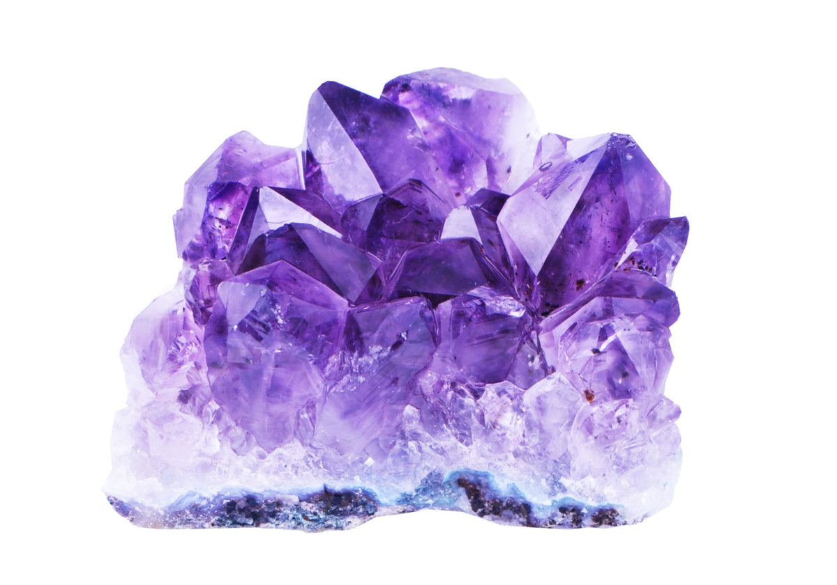 A raw amethyst stone sits on a white background. 