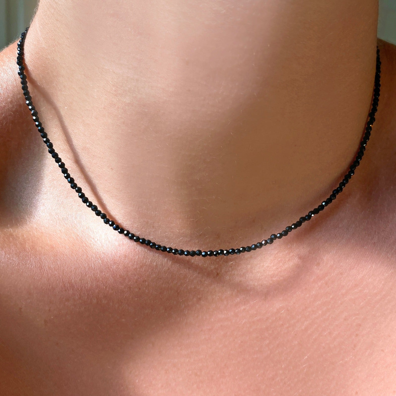Shimmering slim gemstone beaded necklace made of 2mm faceted stones in Black Spinel on a gold linking lobster clasp. 