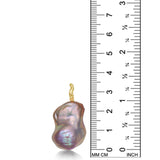 A blush pink baroque pearl pendant from AMANDA PEARL with a recycled 14K yellow gold ripple bale stands next to a ruler for scale.