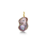 A blush pink baroque pearl pendant from AMANDA PEARL with a recycled 14K yellow gold ripple bale sits on a white background. 