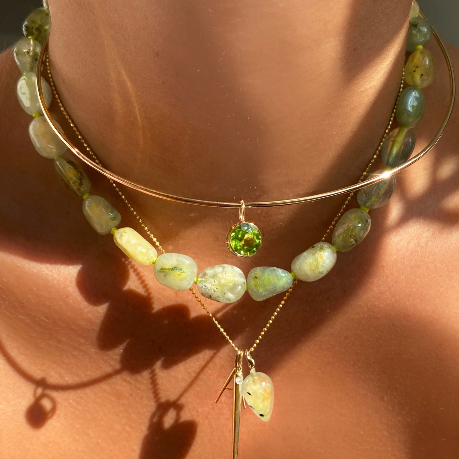 14k gold Wire Choker Necklace. Styled on a neck with a rounded Peridot solitaire charm layered with Nugget collar and chain and charm