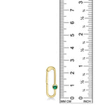 14K yellow gold charm lock with a emerald stone, set against a ruler for scale, on a white background.