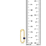 A 14K recycled yellow gold charm lock with lapis gemstone cabochon set against a ruler showing its height to be 25mm tall. 
