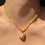 Eclipse Opal Necklace with Golden Baroque Pearl Charm hanging from Neck.