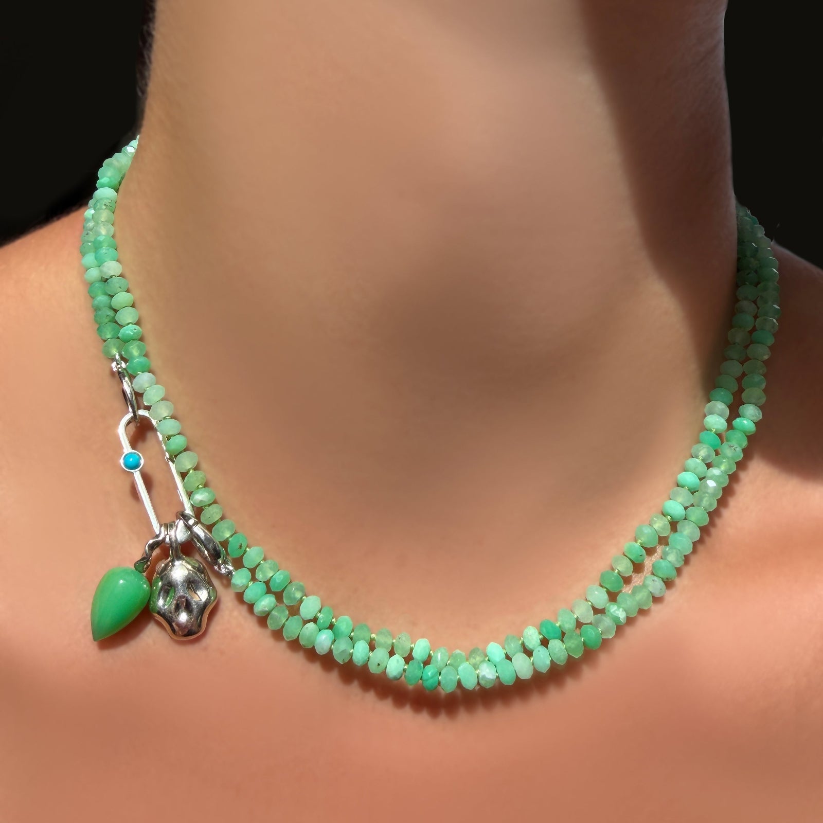 2 AMANDA PEARL Faceted Chrysoprase Necklaces on Sterling Silver Evolution Clasp with a paperclip charm lock with turquoise cabochon holding a chrysoprase drop charm and molten skull charm on a model's neck.