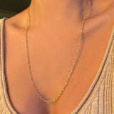 Irregular cable chain worn at 24" paired with a beige scoop neck knit.