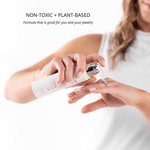 Person applying a white cream to their hand with text about non-toxic and plant-based formula.