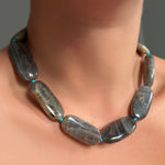Labradorite Long Oval Necklace with blue knotted thread on a model's neck.