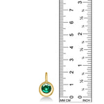 Molten Solitaire Charm in 14k yellow gold with a cultivated emerald, set against a ruler showing a height of 20mm. 