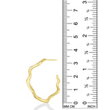 A photo of an undulating hoop earring next to a ruler showing that is is 3.3cm in height. It is made of 14k yellow gold with a rippling shape that is a play on a classic gold hoop earring.