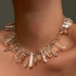 Rock crystal collar with yellow gold linking ovals clasp on a model's neck.