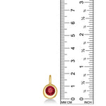 A 14K molten round solitaire charm bezel set with an ethical lab grown round Ruby stone set against a ruler to show it's scale. 