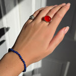 A model wearing an AMANDA PEARL faceted lapis beaded bracelet along with a recycled sterling silver molten skull pinky ring and molten pebble ring with carnelian.