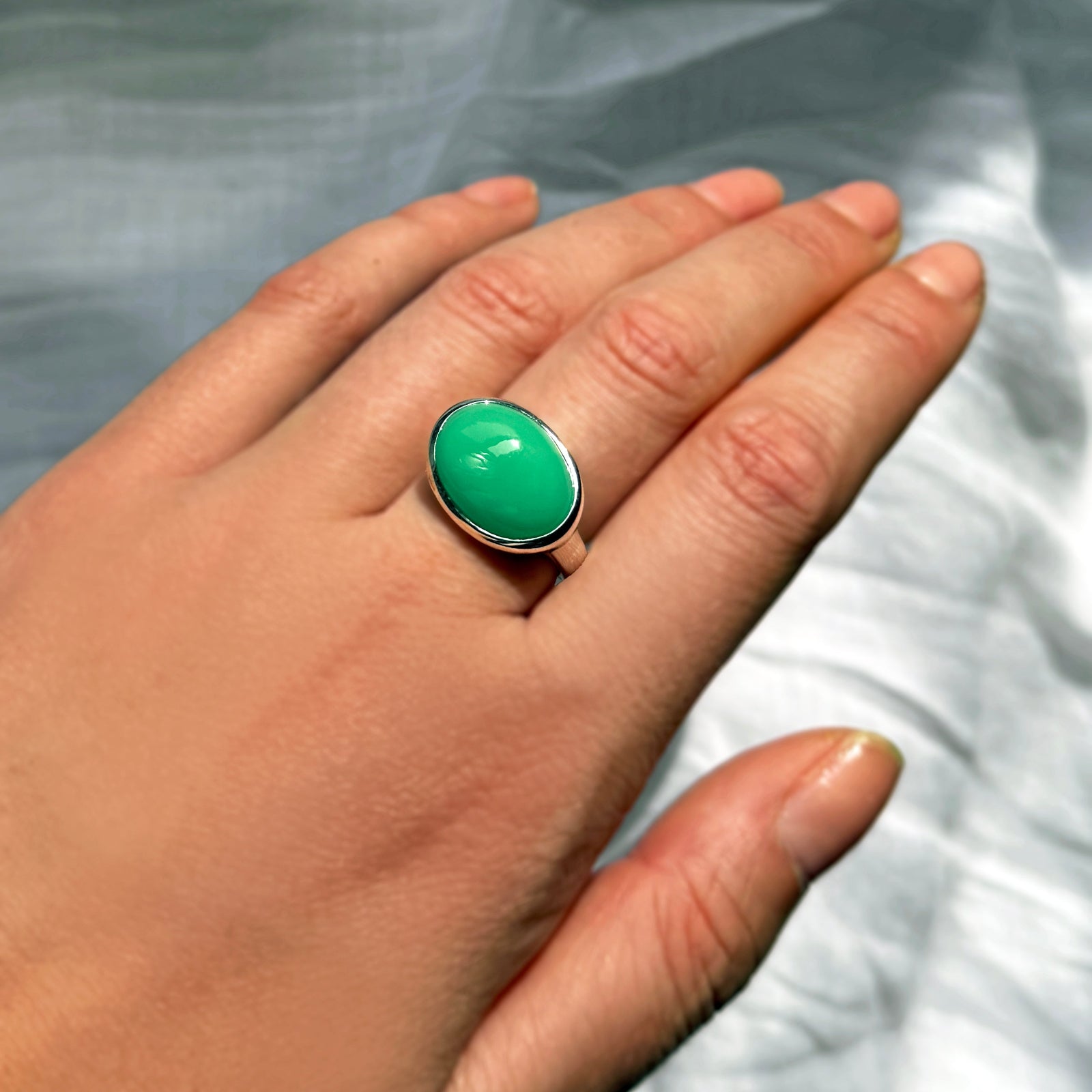 An AMANDA PEARL recycled sterling silver molten pebble ring with chrysoprase cabochon.