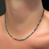 An AMANDA PEARL 2mm faceted chrysocolla necklace on a model's neck with recycled 14k gold clasp.