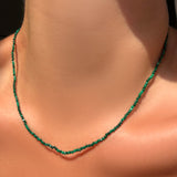 AMANDA PEARL 2mm faceted malachite slim gemstone necklace with recycled sterling silver clasp on a model's neck.