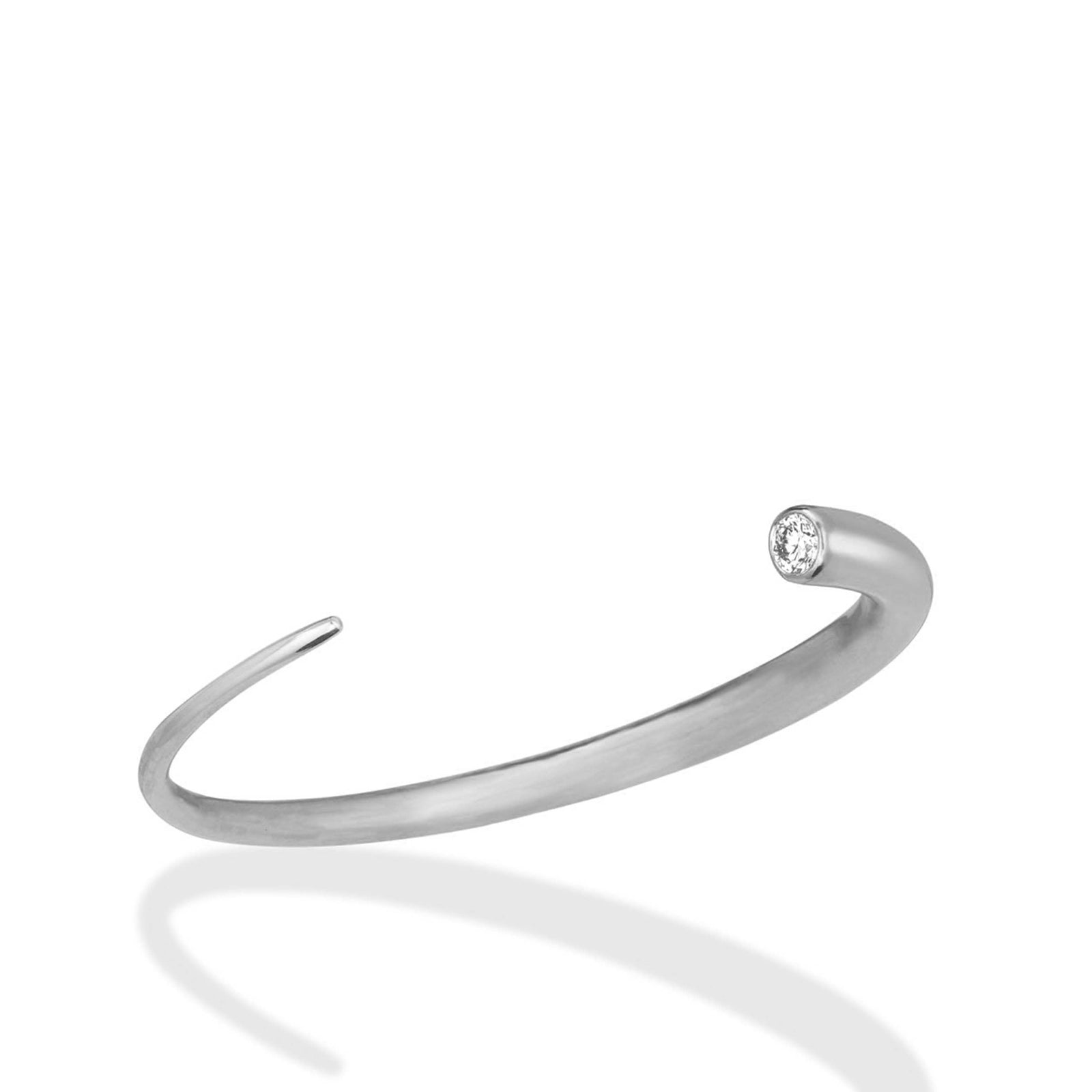 A 14K recycled white gold quill cuff with lab grown white diamond on a white background. 