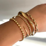 bead chain with 3mm bracelet, quill cuff tibet chain bracelet, molten cuff drop link chain bracelet on a model's wrist.