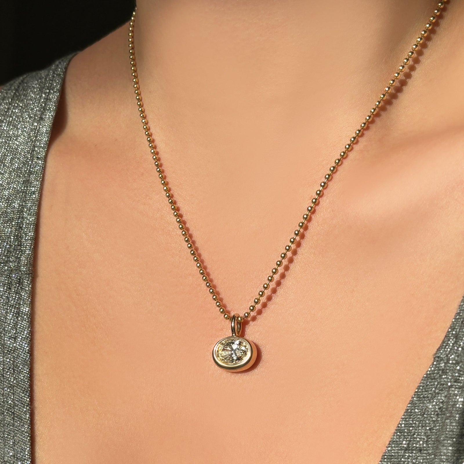 14K Recycled Gold Molten Solitaire Oval Charm styled on a Yellow Gold Bead Chain 