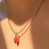 Carnelian Acorn Drop Charm with 14K recycled gold bale with ripple detail styled on a gold beaded chain on a neck