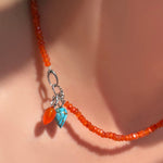 The AMANDA PEARL Faceted carnelian necklace with carnelian and turquoise drop charms strung on the linking ovals clasp in sterling silver. 