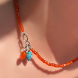 The AMANDA PEARL Faceted carnelian necklace with carnelian and turquoise drop charms strung on the linking ovals clasp in sterling silver. 