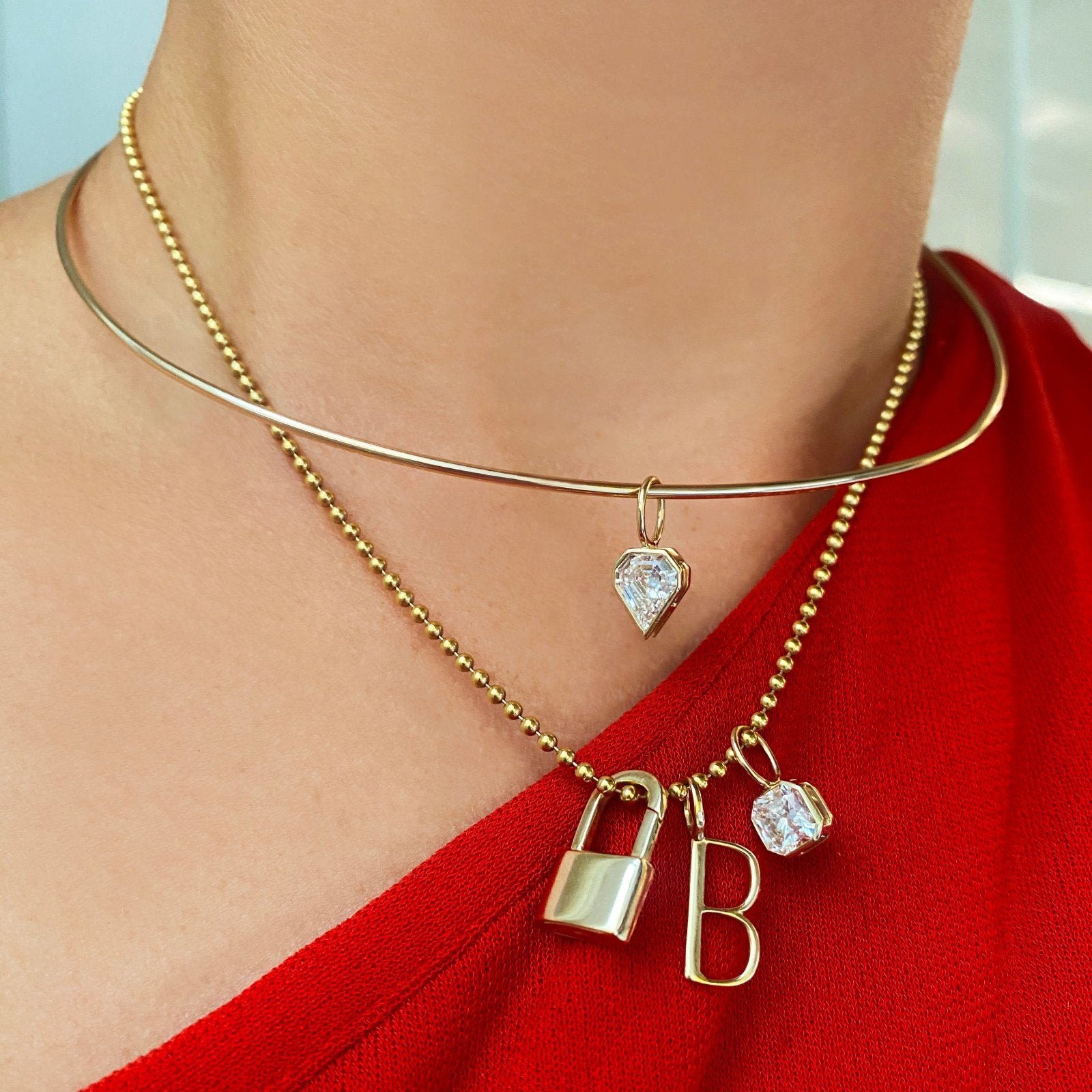 14K Gold Wire Choker Necklace styled with a diamond charm attached layered with a gold bead chain with charms attached