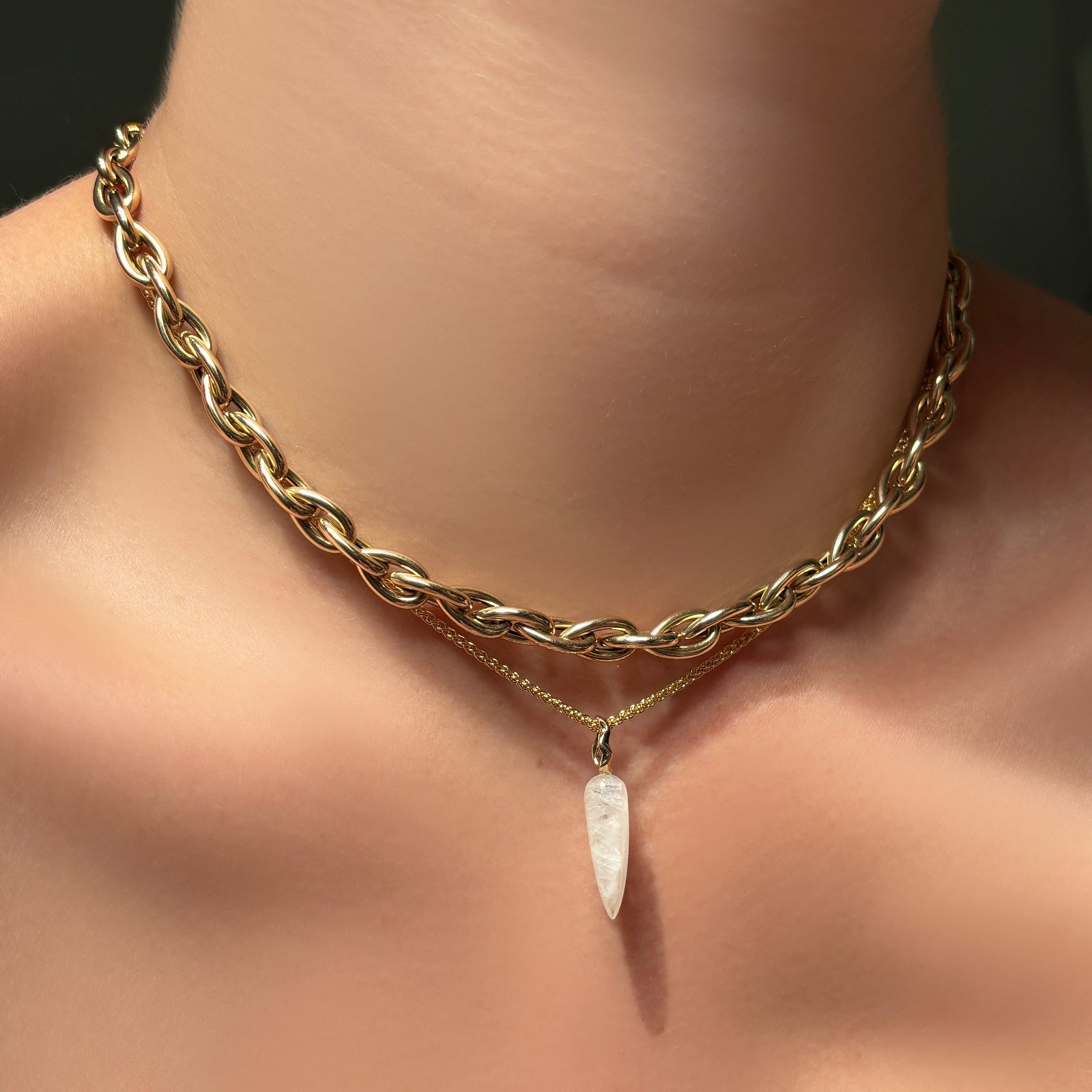 Chunky drop link chain layered over a wheat chain necklace with moonstone drop charm on the neck.