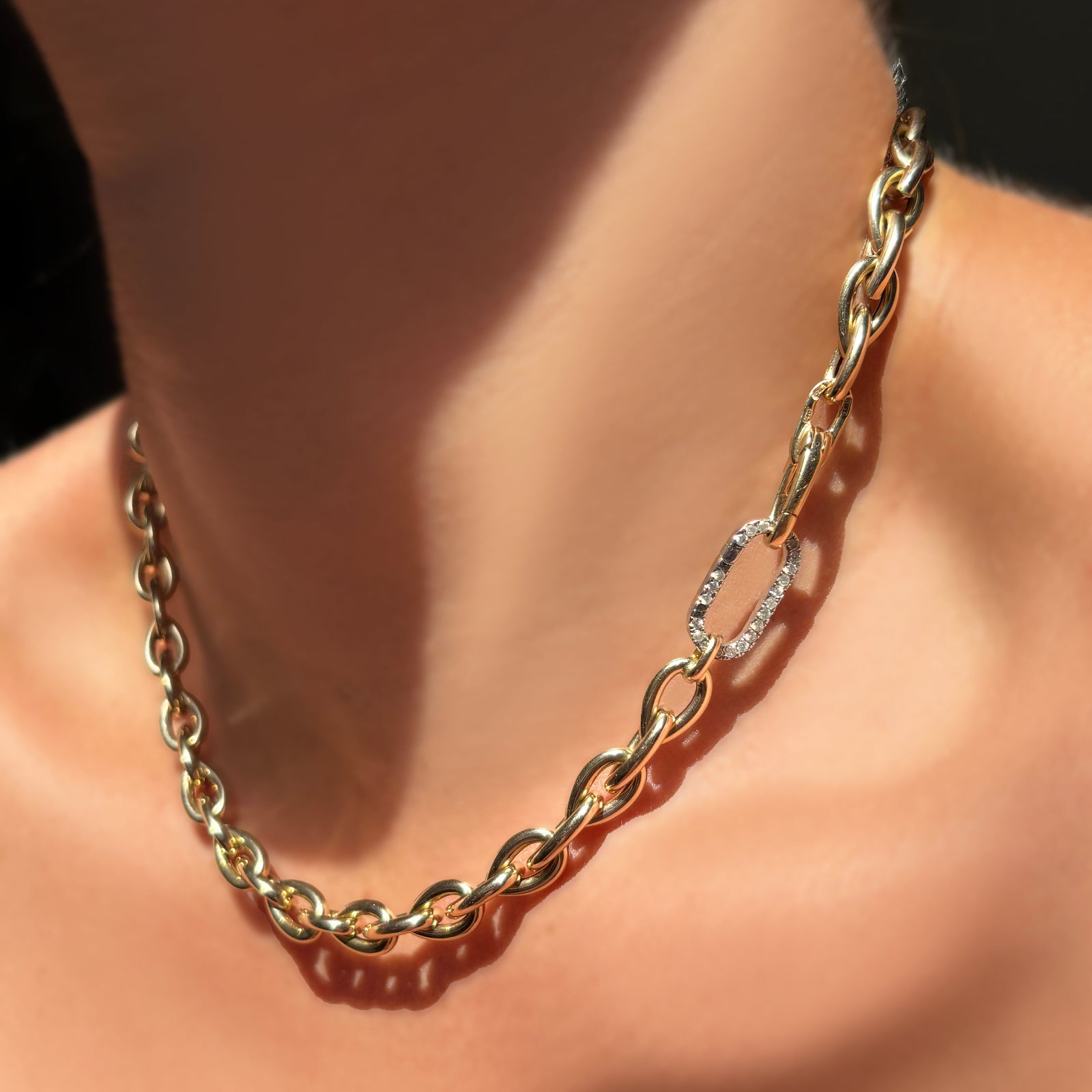 drop link chain necklace in 14k yellow gold with a medium diamond pavé face charm lock on a model's neck.
