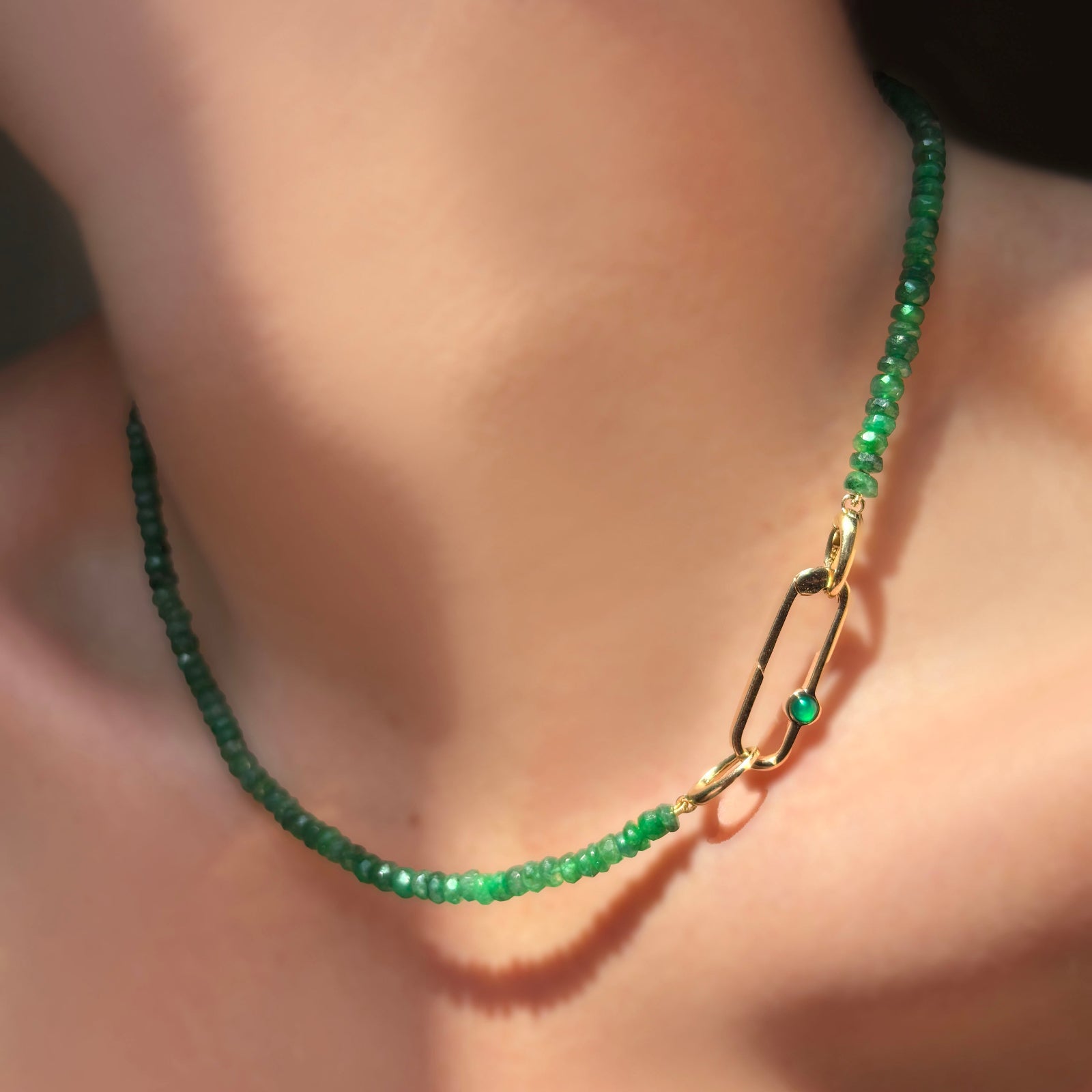Faceted Emerald Necklace with evolution clasp, attached with a Paperclip Charm lock with green onyx cabochon on a model's neck.