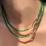Faceted Emerald Necklace holding a paperclip charm lock with green onyx cabochon layered with another emerald necklace with small emerald charm lock on a model's neck.