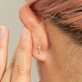 A model shows the flat backs on her ear featuring the AP logo.