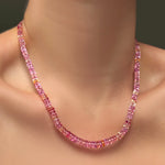 A single AMANDA PEARL hibiscus sapphire necklace on a model's neck.