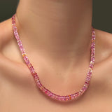 A single AMANDA PEARL hibiscus sapphire necklace on a model's neck.