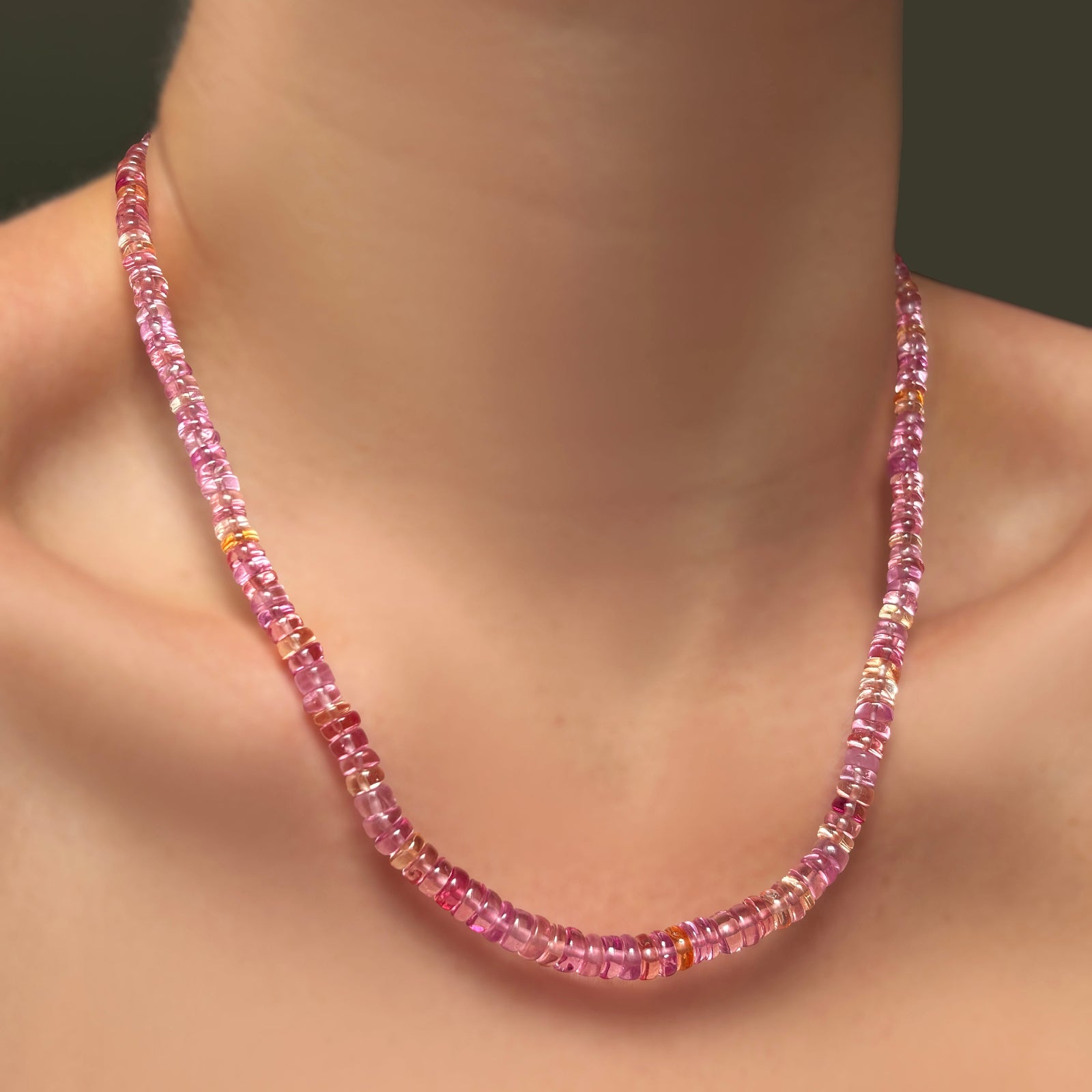 A single AMANDA PEARL hibiscus sapphire necklace on a model's neck.