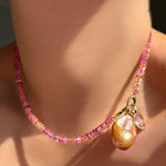 AMANDA PEARL Hibiscus Sapphire Necklace with its Evolution Clasp turned toward the front holding a blush baroque pearl and molten knot charm with amethyst.