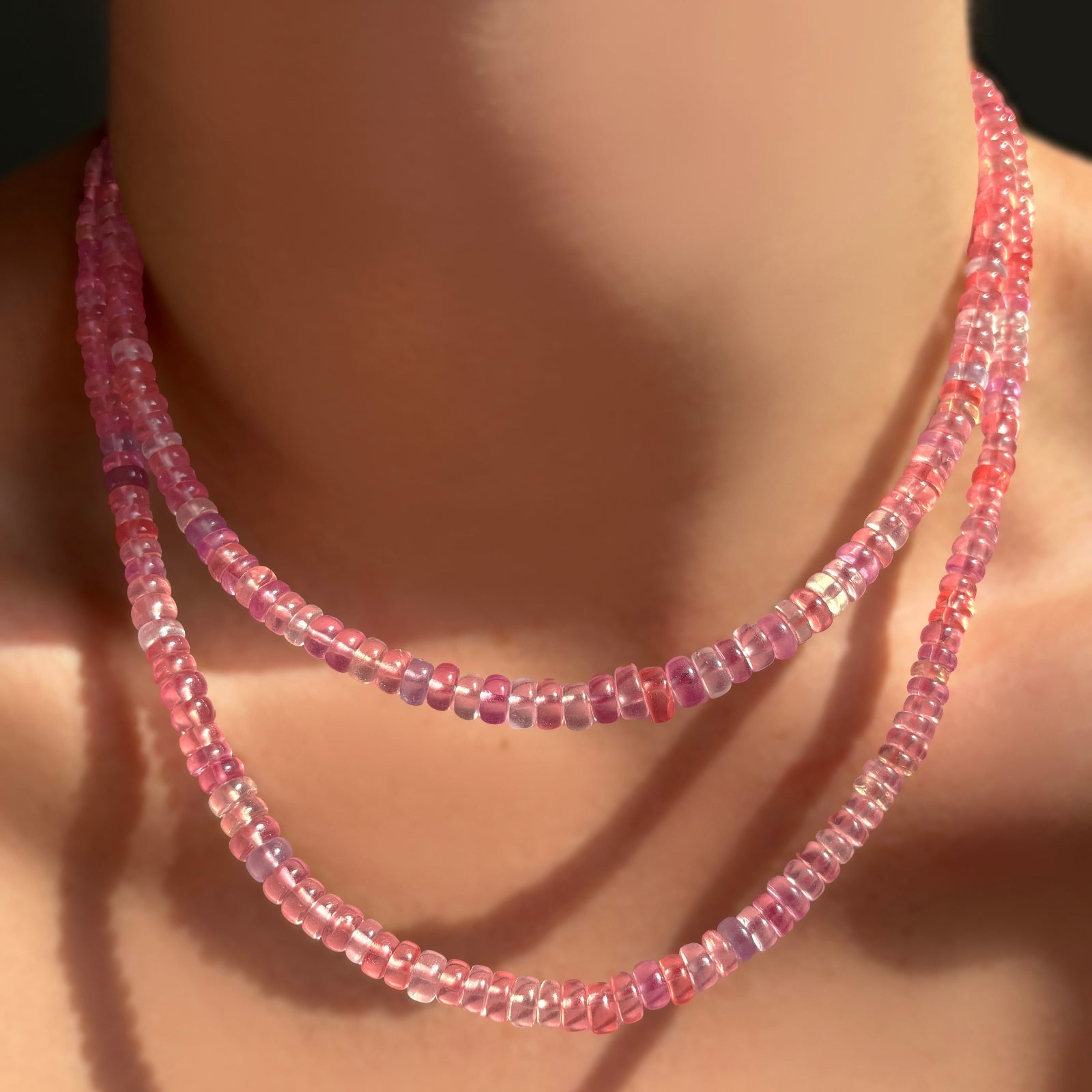 A 16" and 18" AMANDA PEARL Hibiscus Sapphire Necklace layered together on a model's neck.