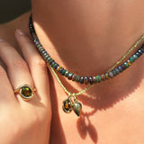 Pyrite acorn drop charm. Styled on a neck with a molten knot charm hanging from a beaded necklace.