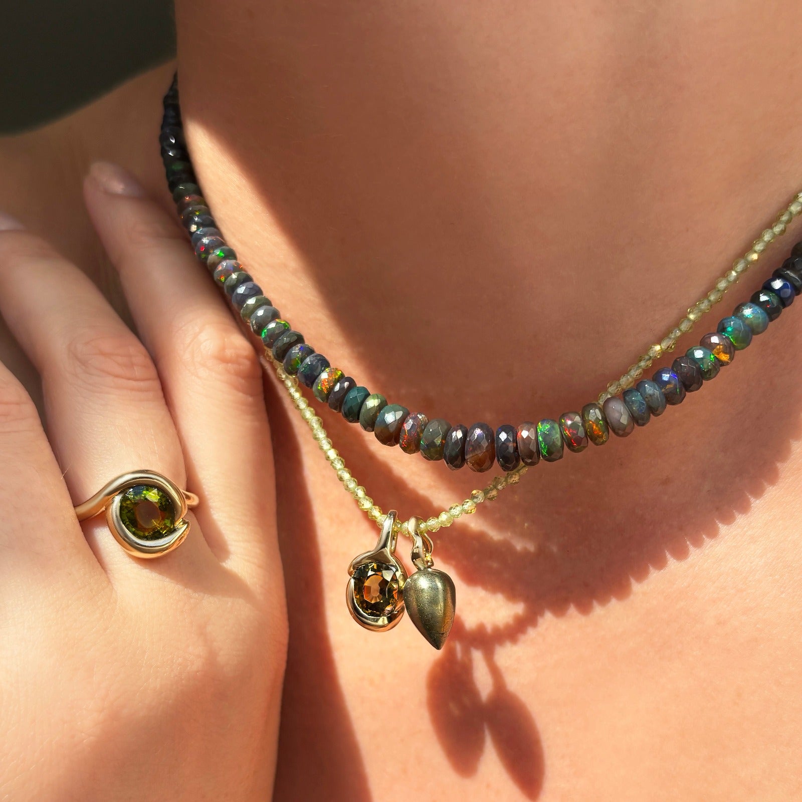 Pyrite acorn drop charm. Styled on a neck with a molten knot charm hanging from a beaded necklace.