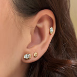 Gold and diamond studs up the ear.