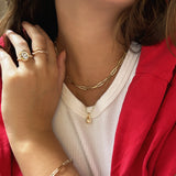 14k yellow gold paperclip chain necklace styled with the Diamond Cut Bead Chain and the Gold Molten Drop Charm cast in recycled 14K yellow gold. The model wears a molten knot diamond engagement ring with lab grown diamonds, and two ripple rings, both set with lab grown diamonds. 
