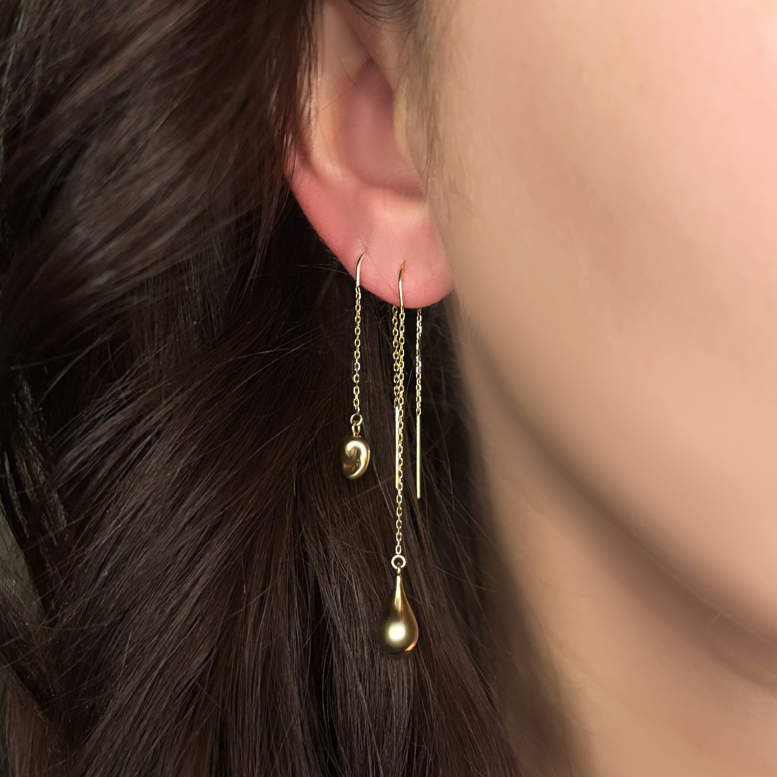 14K Yellow Gold Molten Gold Drop and Droplet on a gold chain hanging from an ear at different lengths. 